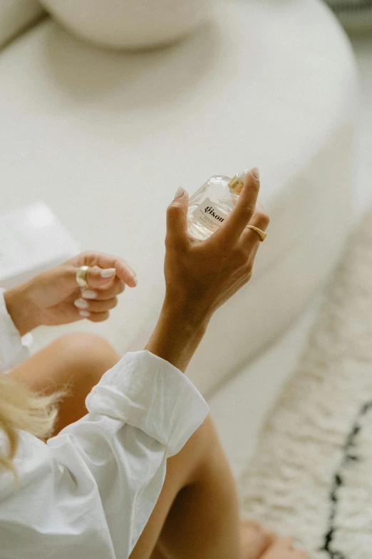 a woman in white dress is holding a bottle of soap