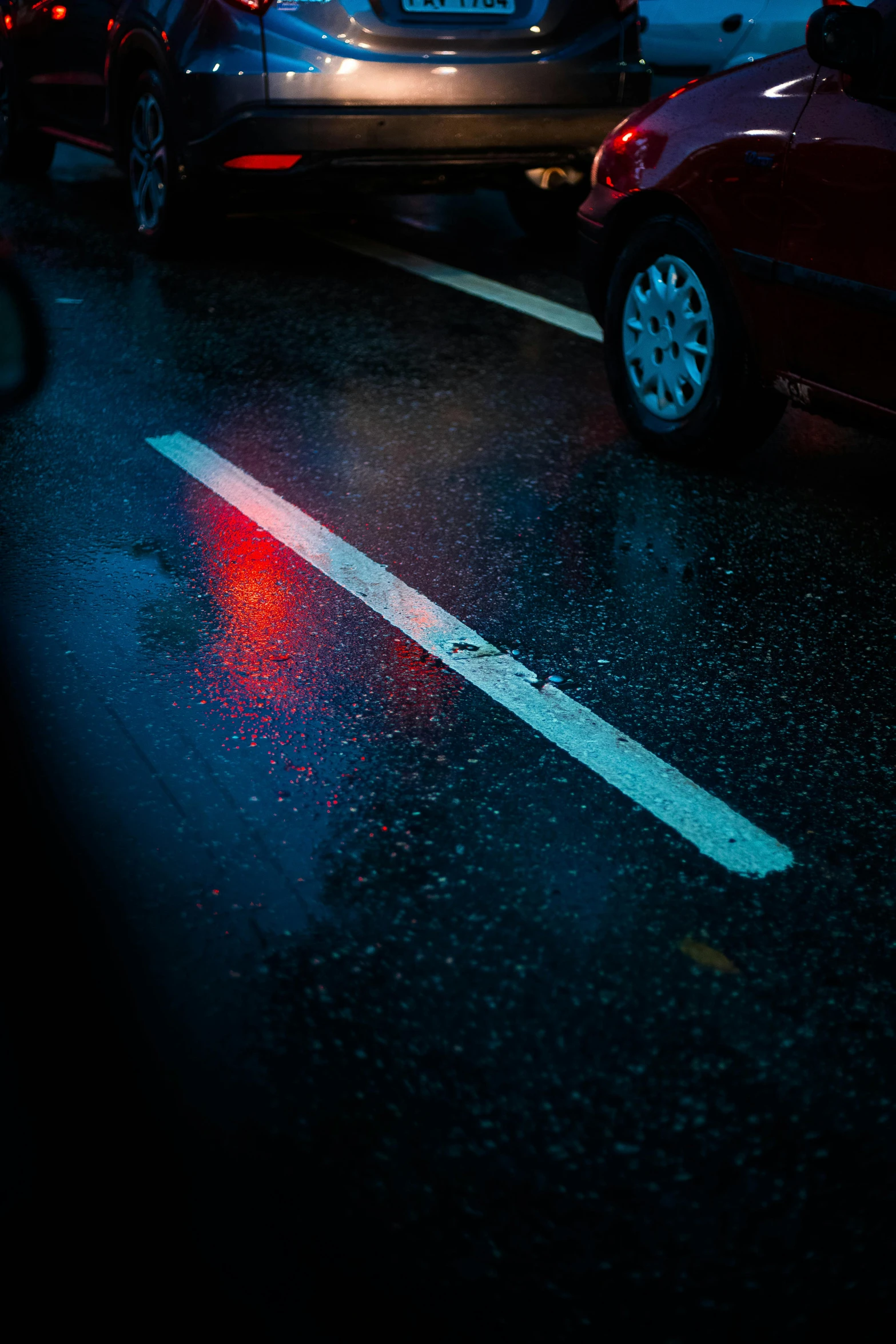 a red car is parked in a lot of traffic