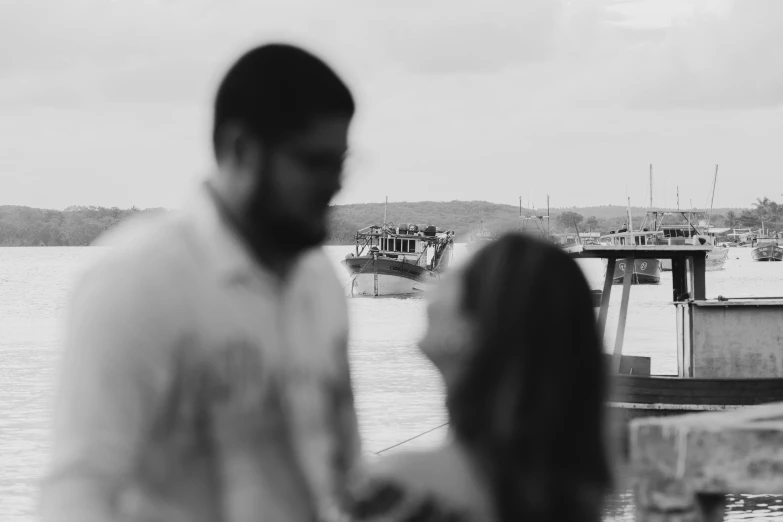 the woman and the man are staring at the boats