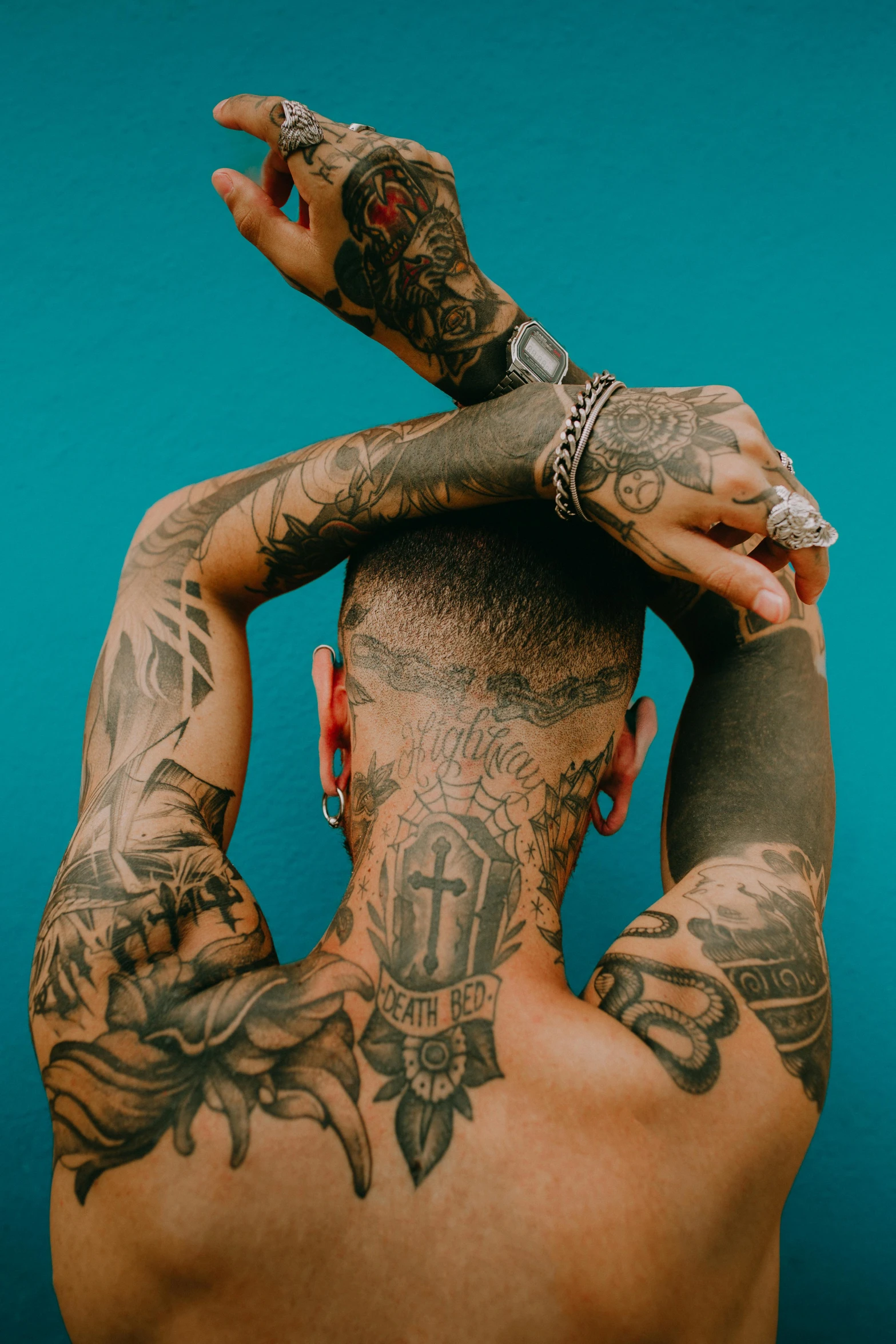 tattooed men posing in front of a blue wall