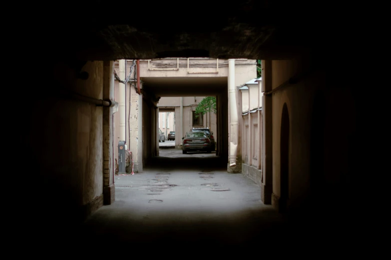 the car is parked inside of the very narrow passageway