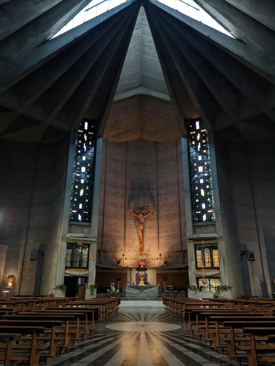 inside a cathedral with stained glass and wooden pews