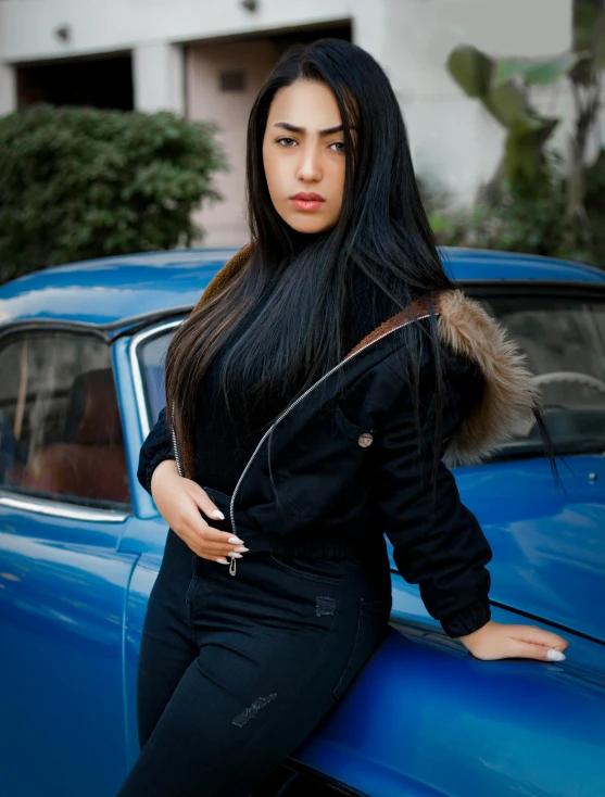 woman standing next to an old classic car posing