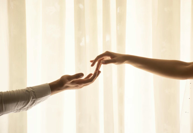 an image of two people holding hands that appear to be touching each other