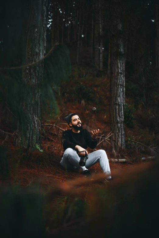 a person sitting in the woods holding soing