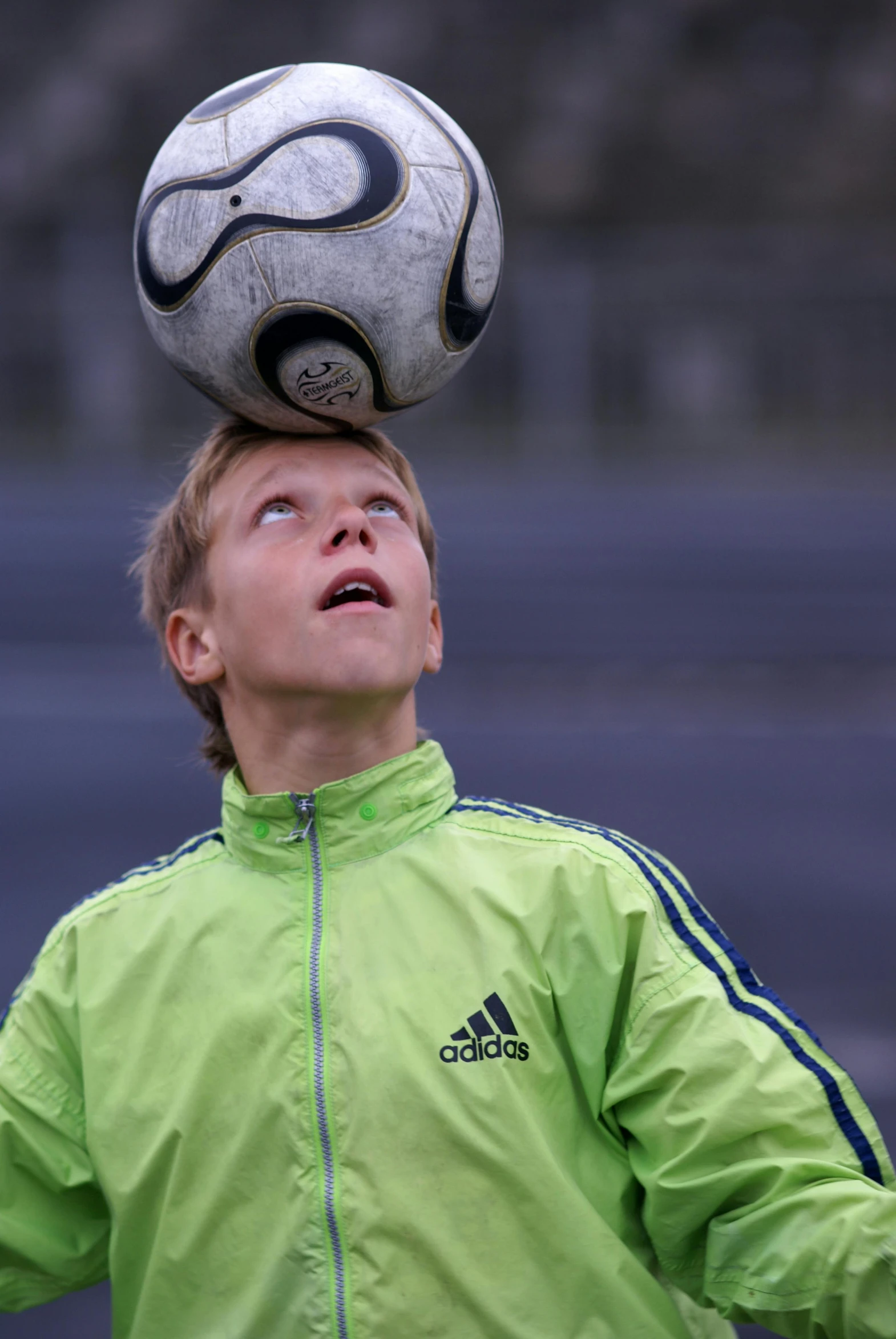 a soccer ball balanced on top of a 's head