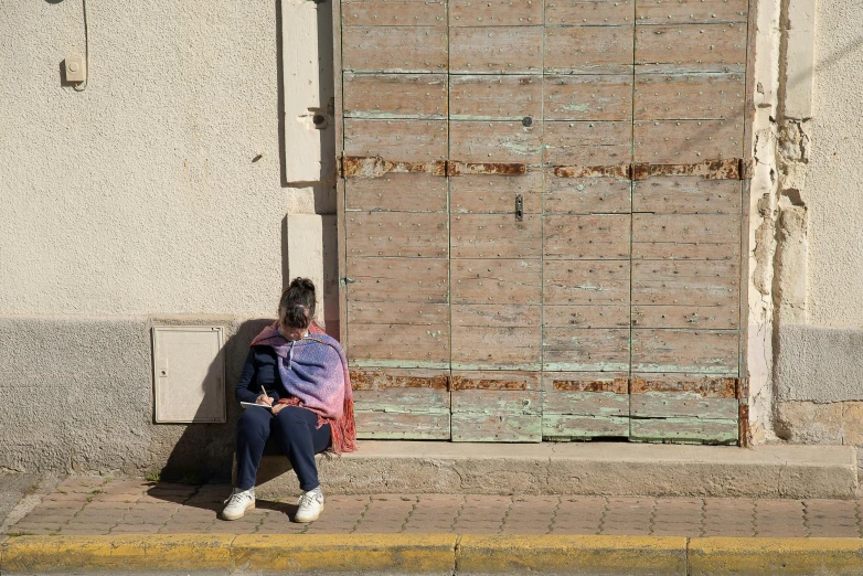 a woman sitting on the sidewalk with a cat