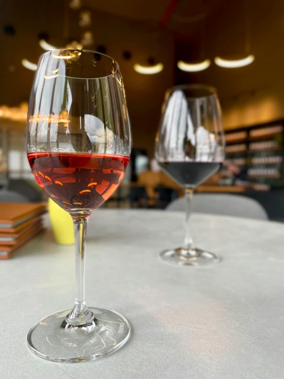 two glasses of red wine sitting on a table