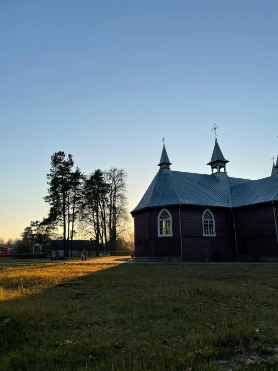 an old, small church sits in the middle of a green field