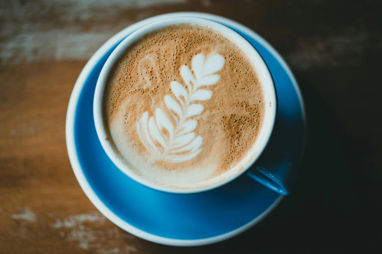 an overhead view of a blue cup containing a latte