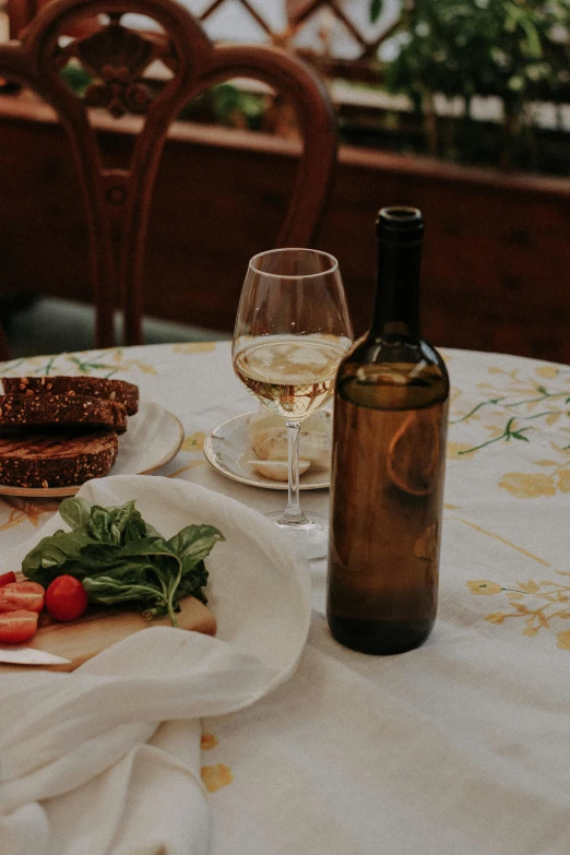 two plates with some strawberries on top of them near a bottle of wine