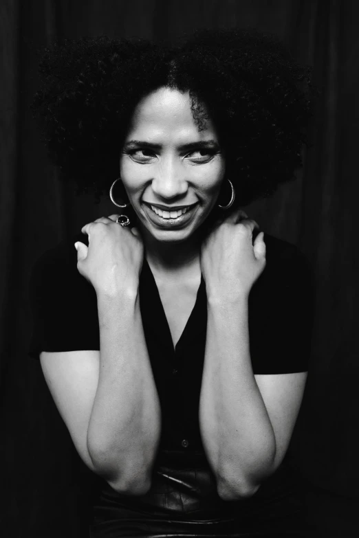 a woman with afros wearing earrings smiling