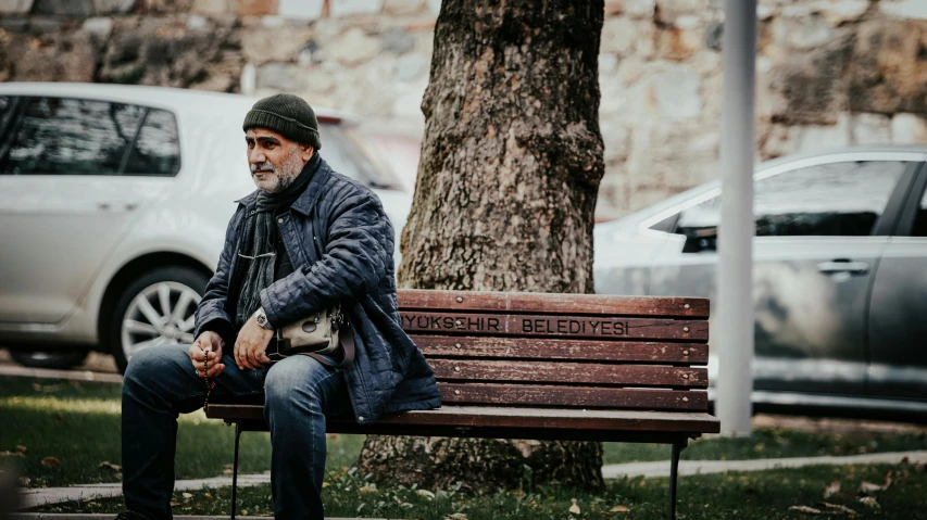 a man sitting on top of a park bench