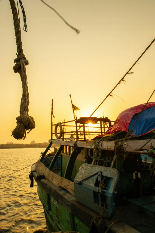 a boat at a pier with the sun setting in the background