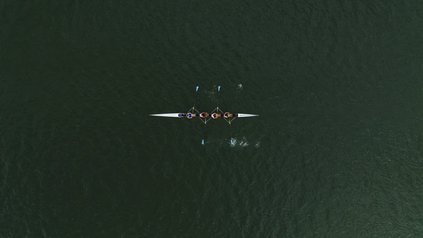 people are rowing in a boat out on the water