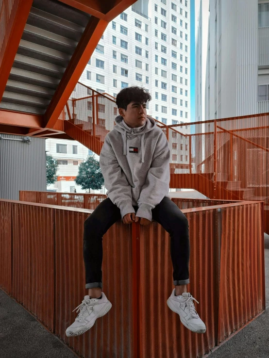 a person is sitting on the edge of a rail outside