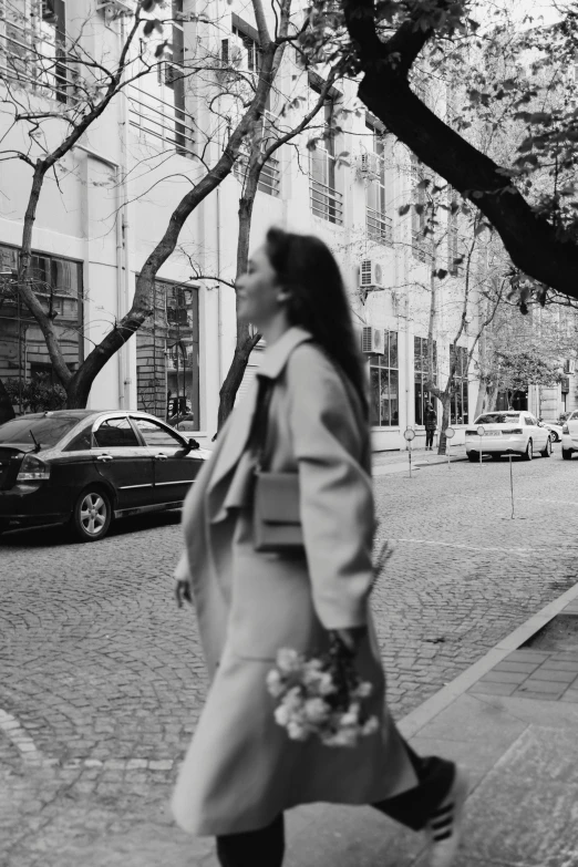 black and white pograph of a woman walking down the street