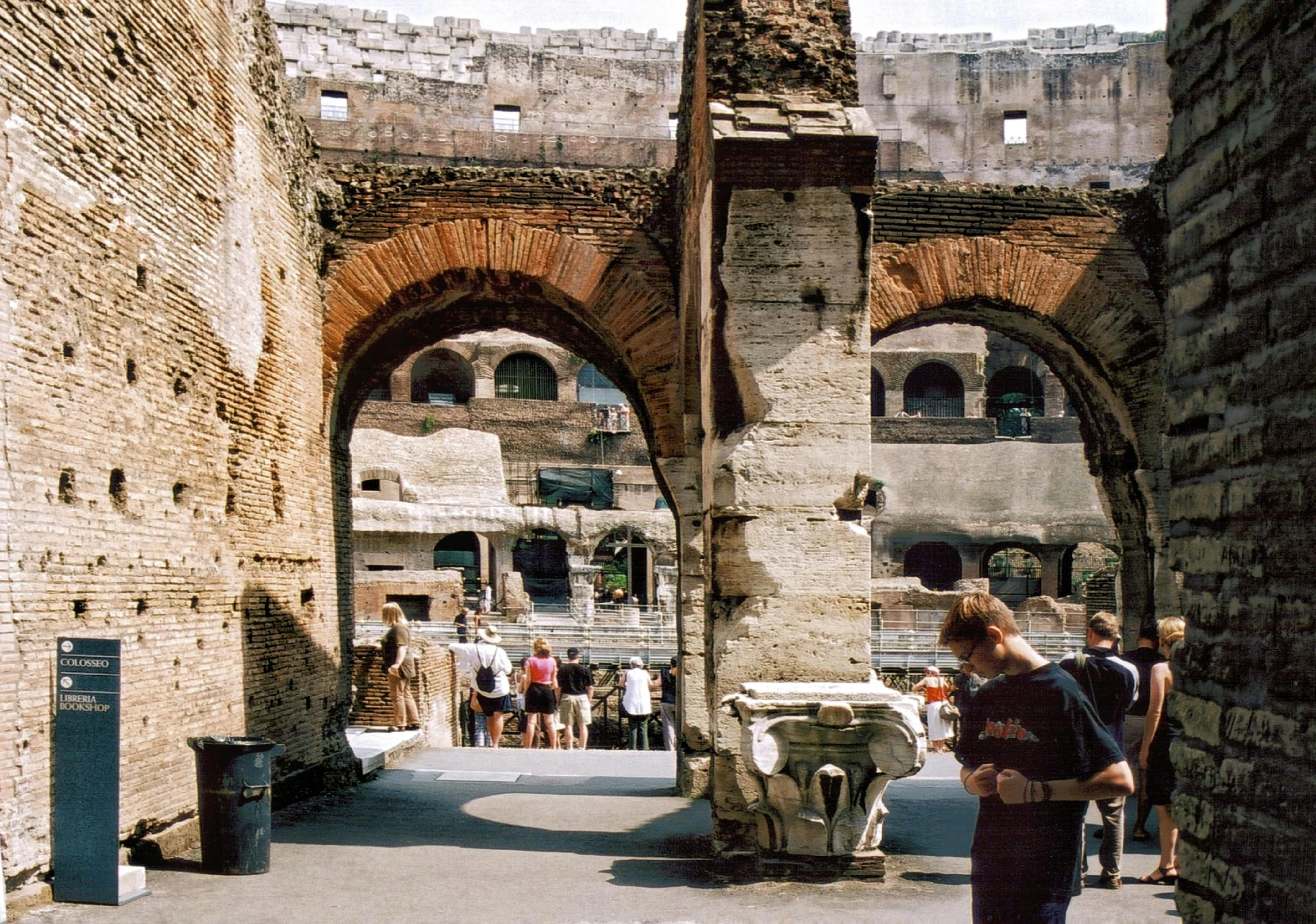 a woman carrying a suitcase next to an archway