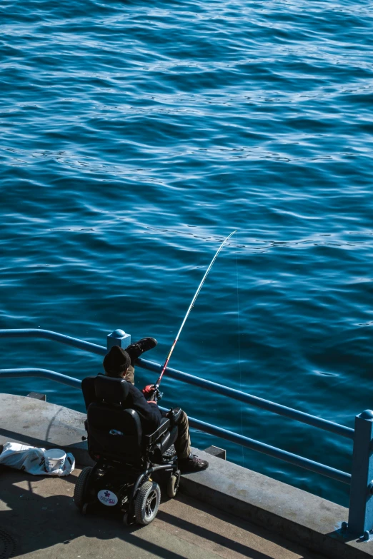 a man on a motor scooter fishing from a pier