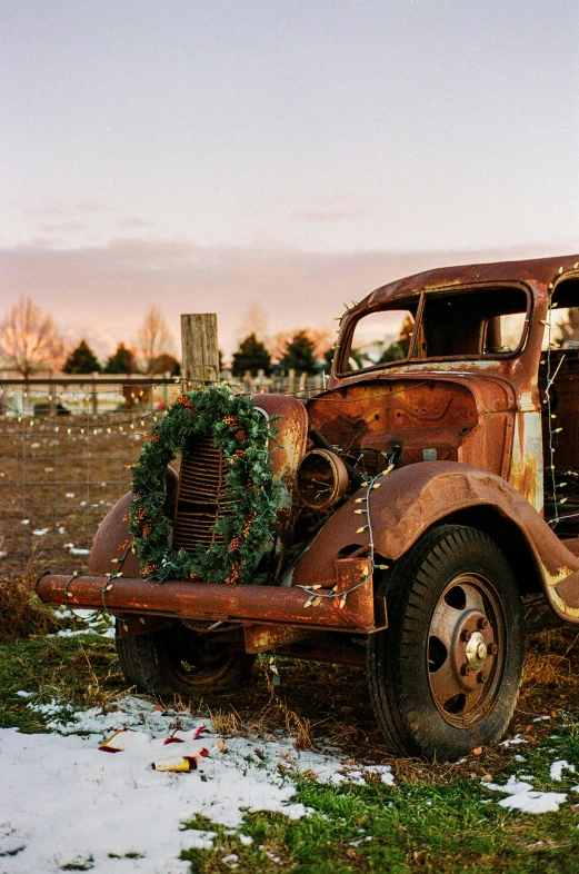 old rusted out truck with wreath in front