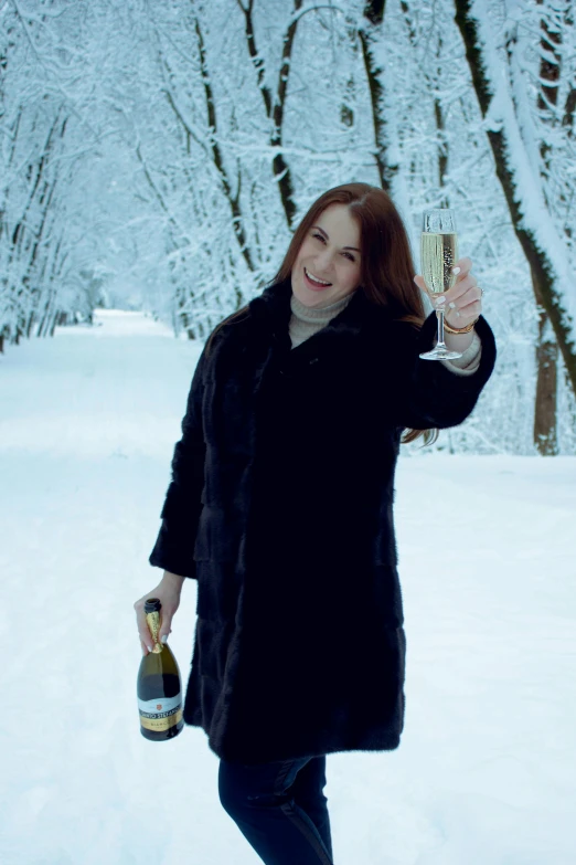 a woman is holding her bottle in the snow