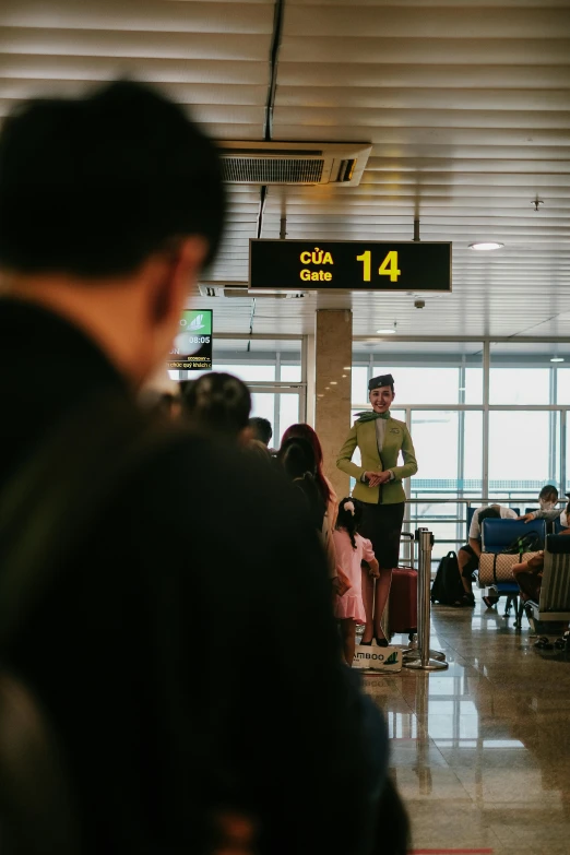 people sitting at tables in an airport lobby with a man standing on the floor