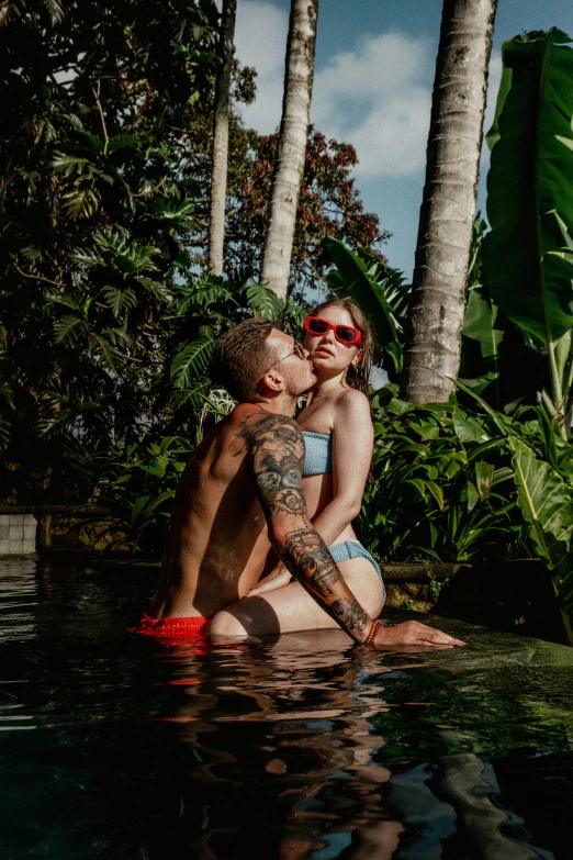 a couple is hugging on the back of a pool