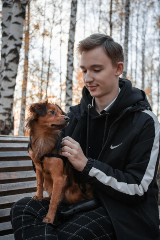  sitting on bench with his dog, outdoors