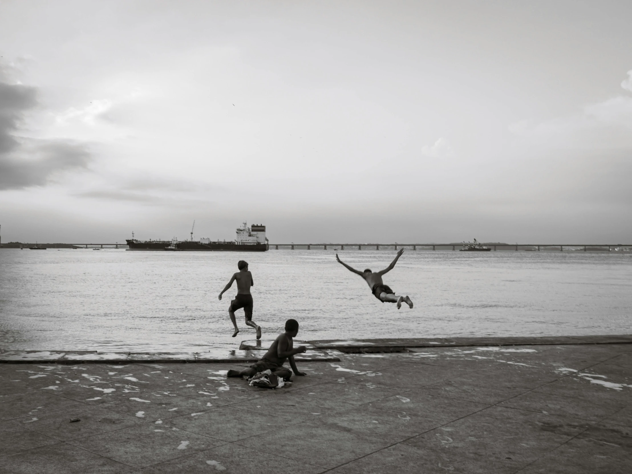 a couple of boys on a beach with the ocean behind them