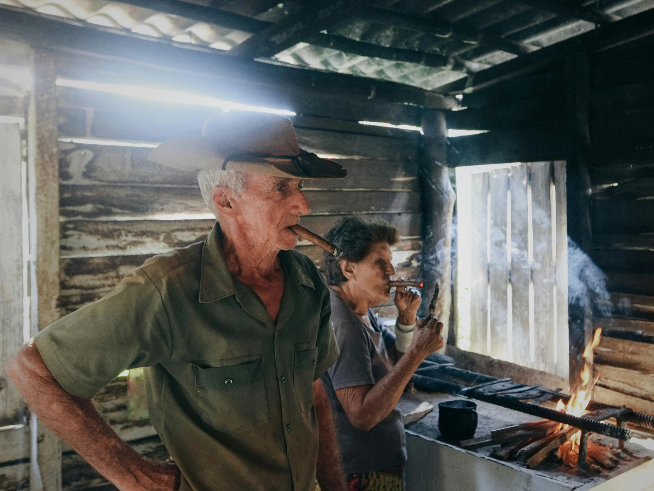 a man and woman are standing in front of an outdoor grill