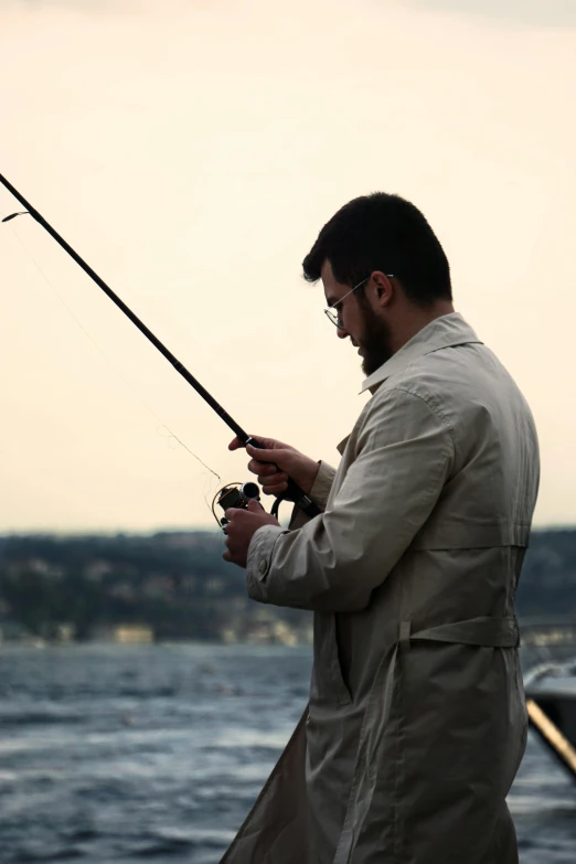 a man standing next to the water fishing
