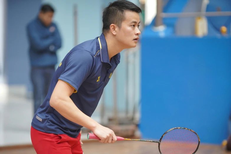 a young man in a blue shirt is playing tennis