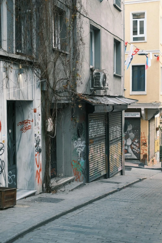 an empty street has a building covered in graffitti