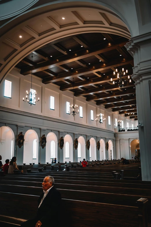 the view of a man sitting in the pews of an old church