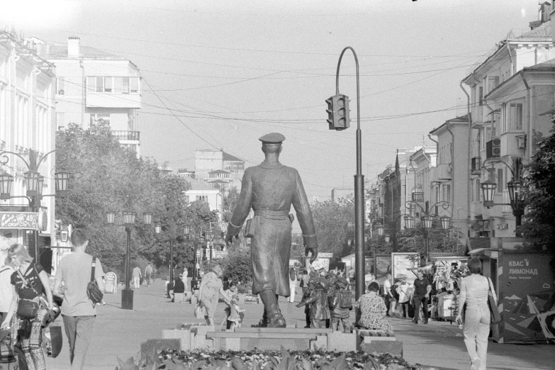 a group of people walking down a city street with tall buildings