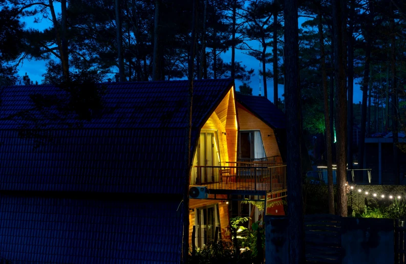 a lit up yellow house on the top of a hill