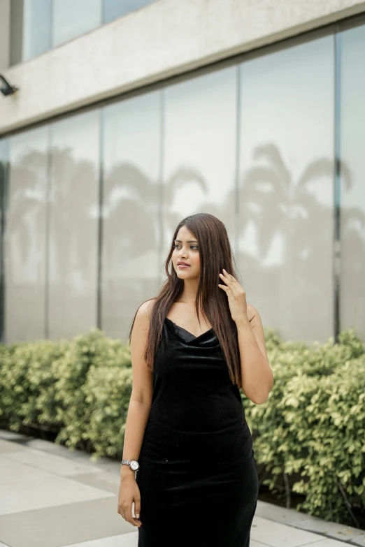 a woman is standing on the sidewalk posing for a picture