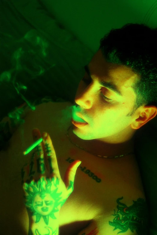 a man with tattoos and green lights in his hand