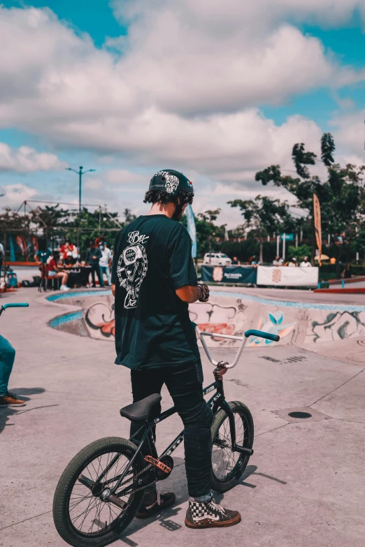 a man stands on top of a skate board in front of a skateboard ramp