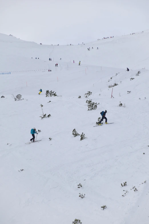 people skiing down the snowy hill in the mountains