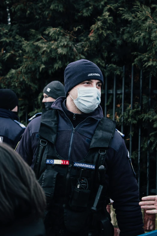 a man in a black jacket wearing a face mask