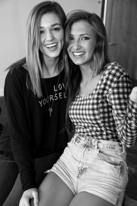 two smiling young women sitting on a couch