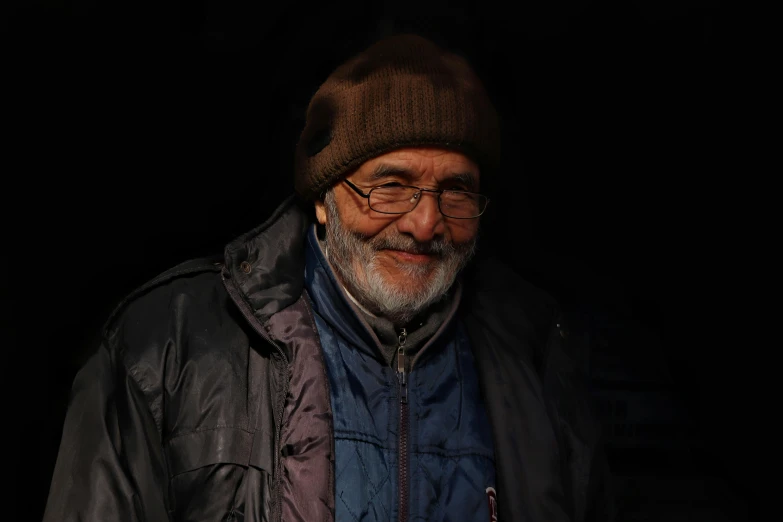 a man in jacket and hat in the dark