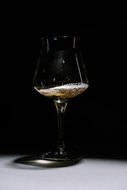 a wine glass with white wine in it on a table