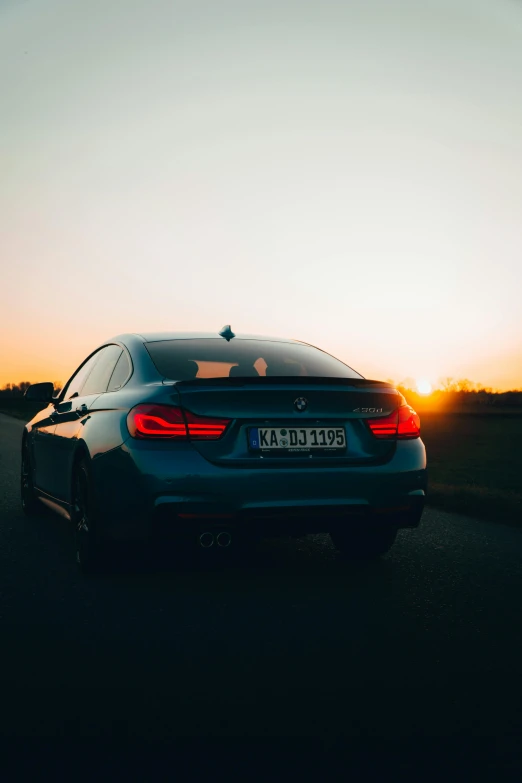 a bmw car is parked on the road at sunset