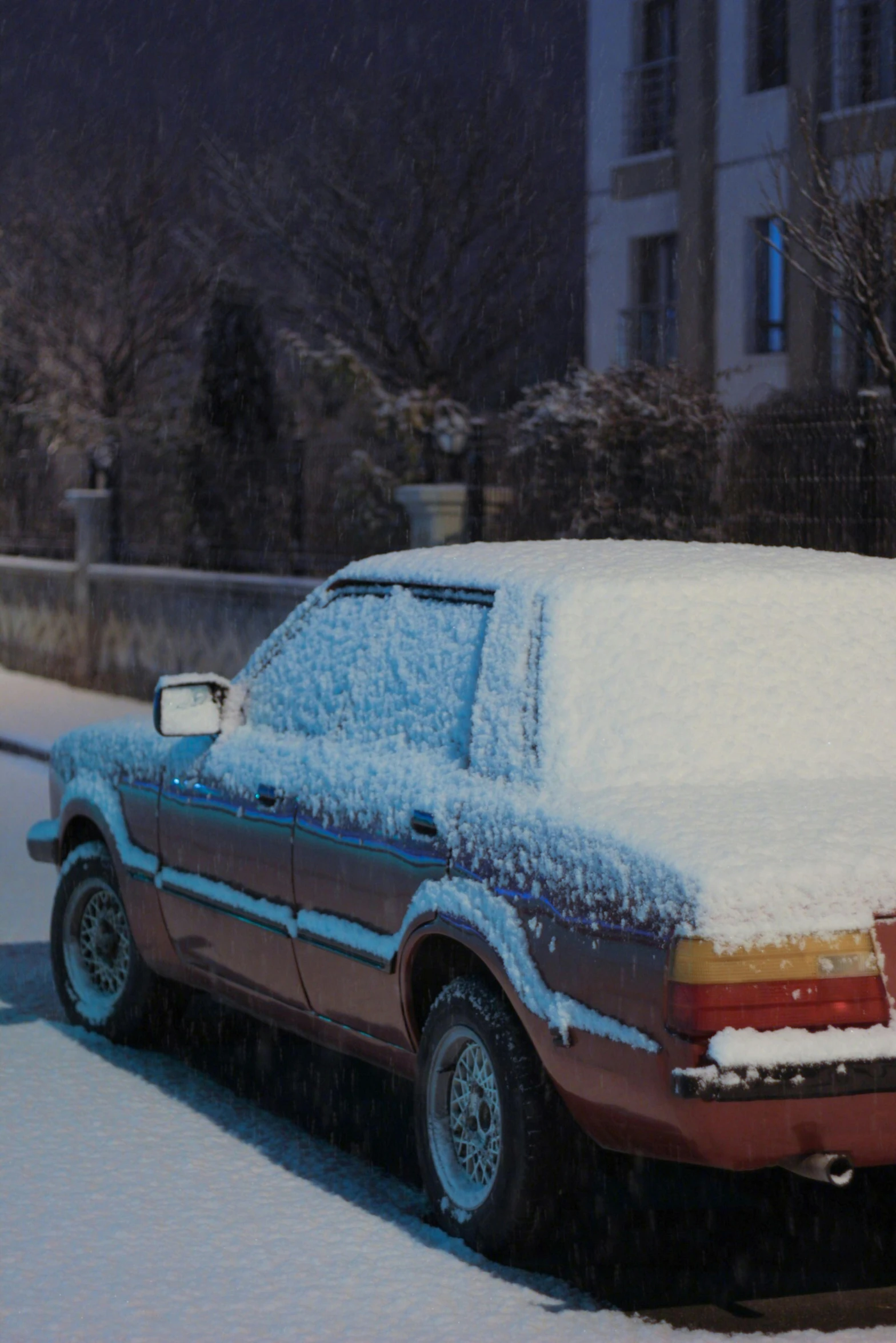 a car is covered with snow and parked in the street