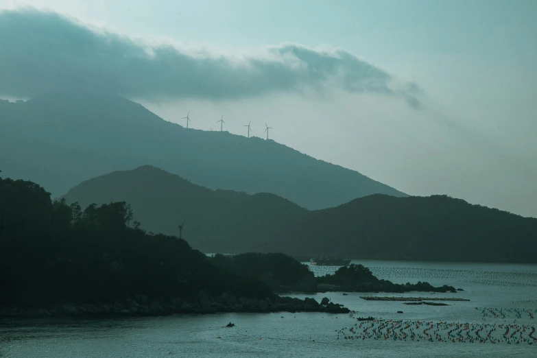 water with a small island and many trees under dark skies