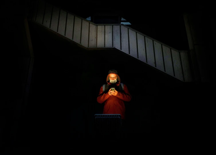 a woman with a phone standing on a staircase