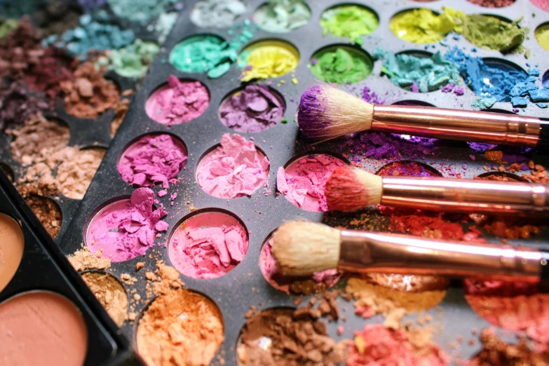 a bunch of powdered colorful eye shadows and a couple brush