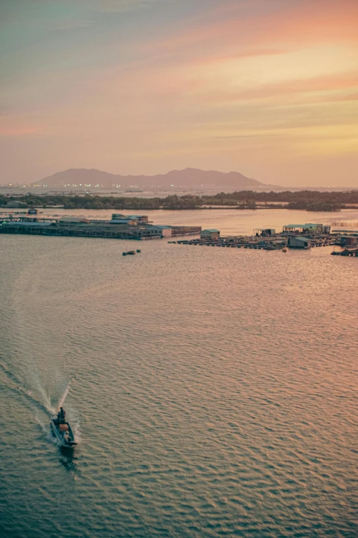 boat on the water at sunset with a pier and many docks